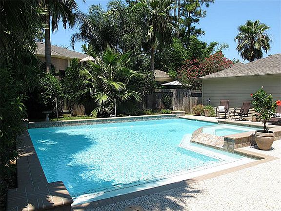 Phenomenal backyard oasis with pool, spa, extensive decking & lush landscape!