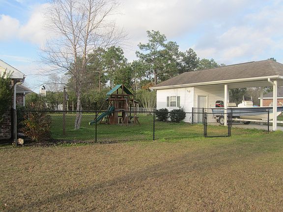 Fenced in backyard with view of shed/workshop and boat/RV carport