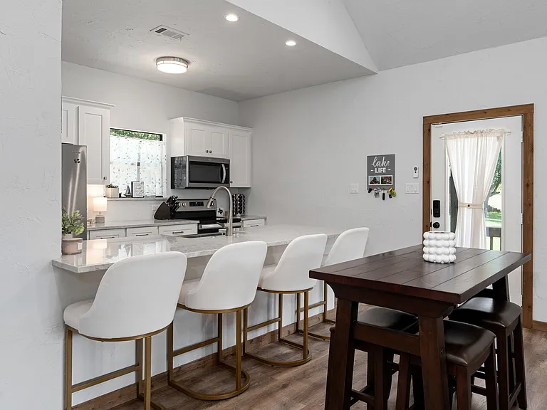 Stylish dining area with a high-top table for 4, plus 4 bar stools at the kitchen counter_perfect for casual meals and socializing.