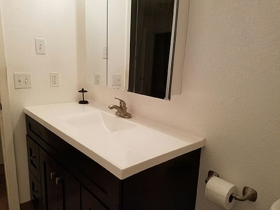 Dark wood vanity in bathroom against clean bright white