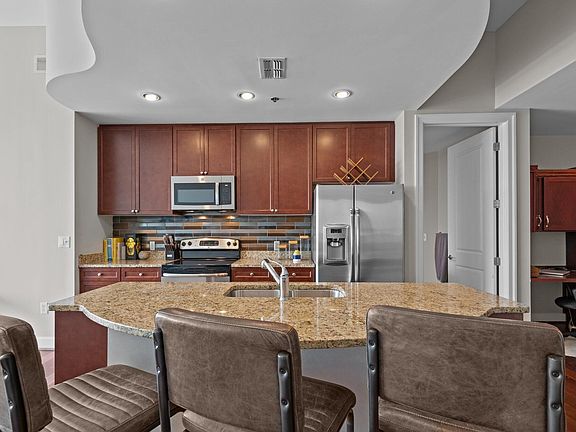 Open concept kitchen with granite countertops, dishwasher and all the other goodies. Finished cheery brown hard wood floors. Floor to ceiling windows, 10 foot high ceilings.