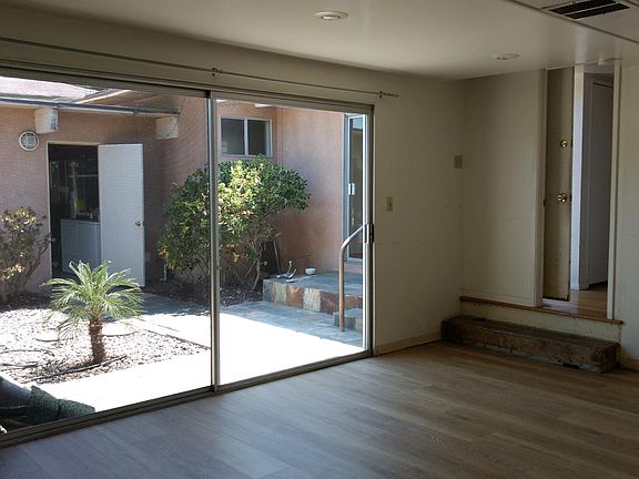 Bedroom 1 with fireplace, big sliding door looking out at the gated court yard.