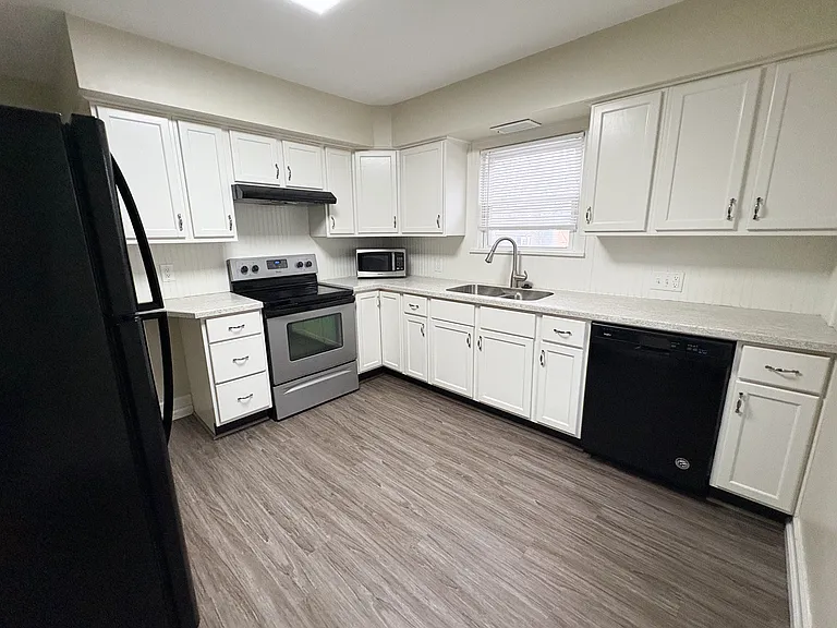 Large kitchen space with newer appliances and cabinets.