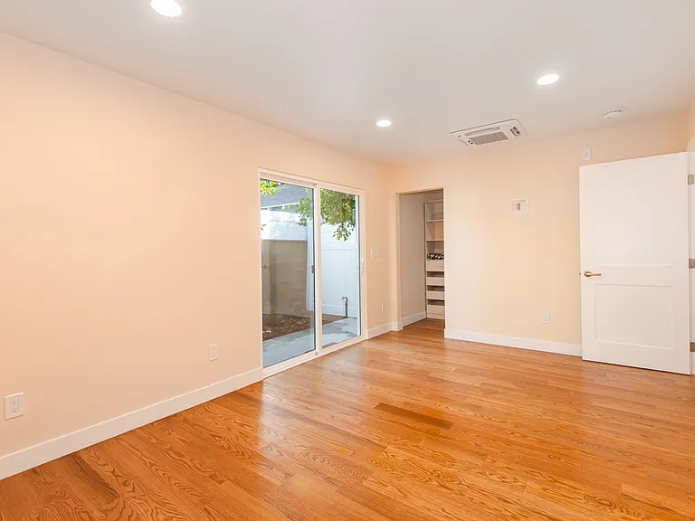 Bedroom with walk in closet and access to private backyard.