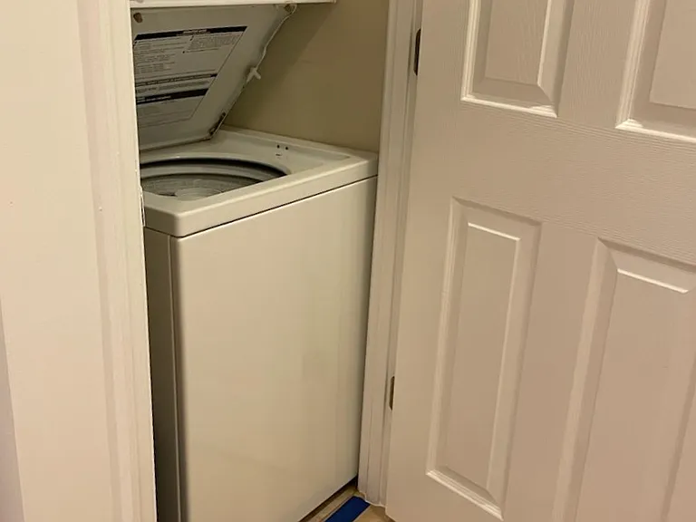 Washer dryer in the hallway right before the bathroom door