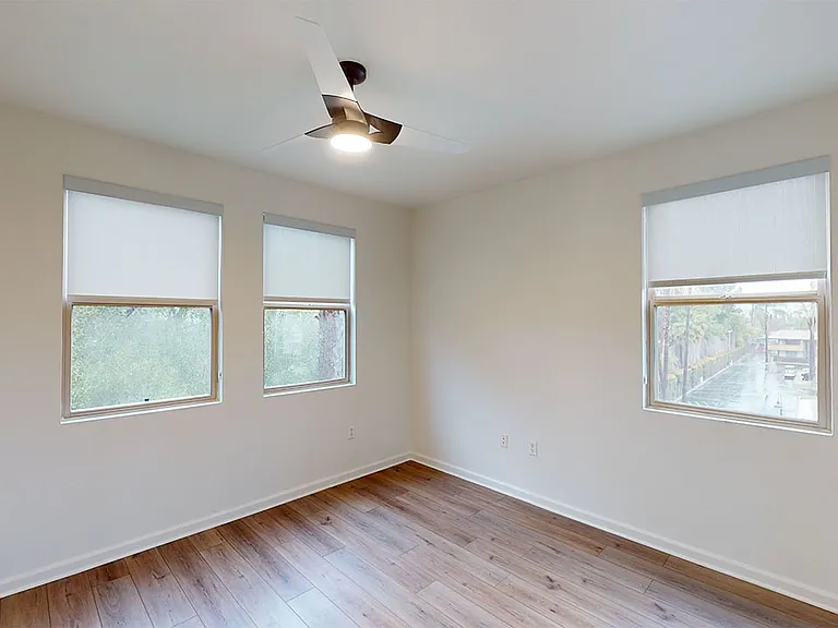 Spacious apartment bedroom with wood-style flooring.