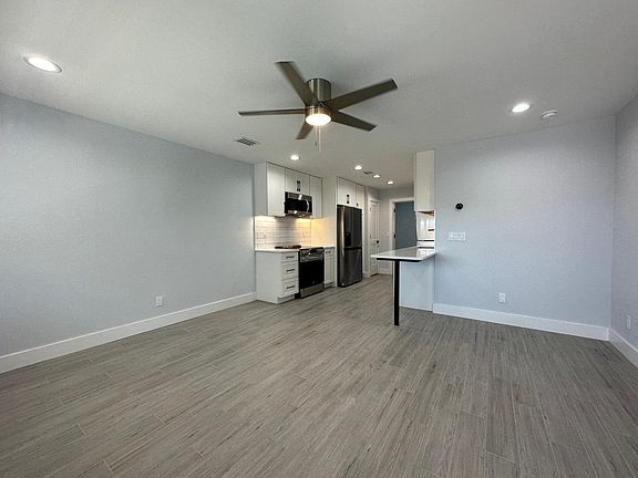 Open floor plan with kitchen leading into living Living room with fan