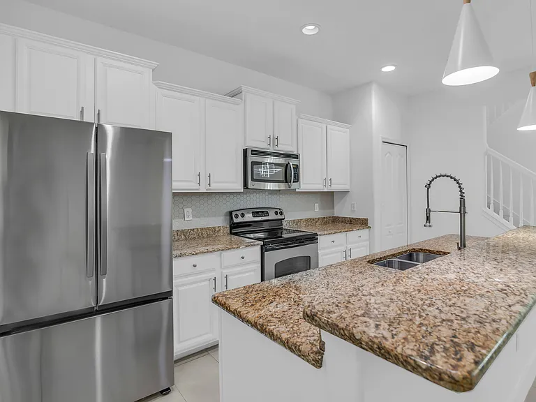Spacious Kitchen that seamlessly opens to Living Room and Dining Room and features granite, stainless steel appliances and large center island with breakfast bar.
