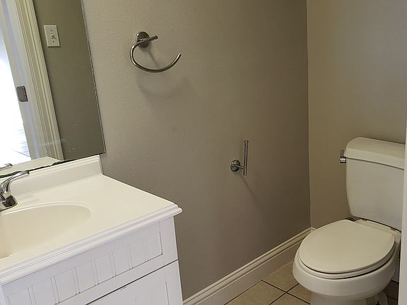 Half bath includes vanity/sink and toilet. Located off kitchen.