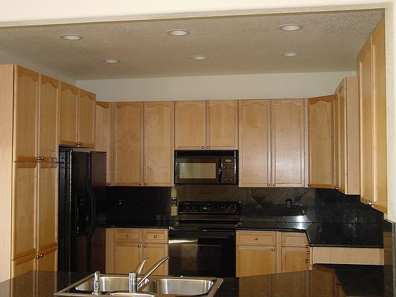 Kitchen with granite countertops/backsplash, hardwood floors & maple cabinets.