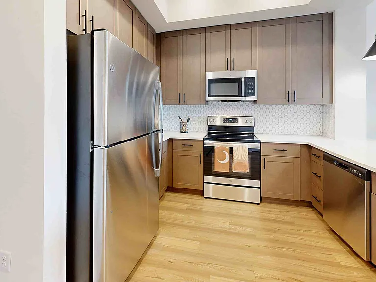Step into this stylish kitchen equipped with high-end appliances and a chic design.
