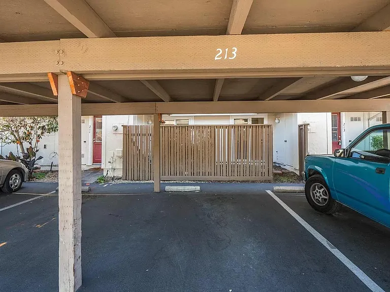 Dedicated covered parking stall for 1 car, additional permit for 1 car for shared uncovered parking stalls in complex. Wooden parking cover in this picture has been replaced with modern steel cover.
