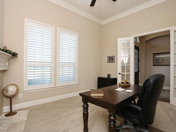 Study has a gas log fireplace with remote. Custom three inch wood shutters on windows and glass pane french doors.