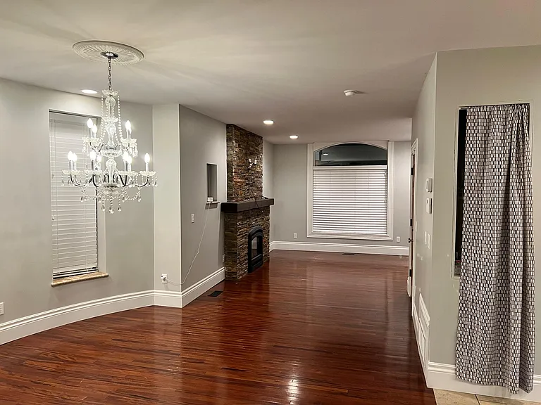 View of Dining area under chandelier, Living Room area next to the big window and fireplace. Kitchen is to the right of this photo