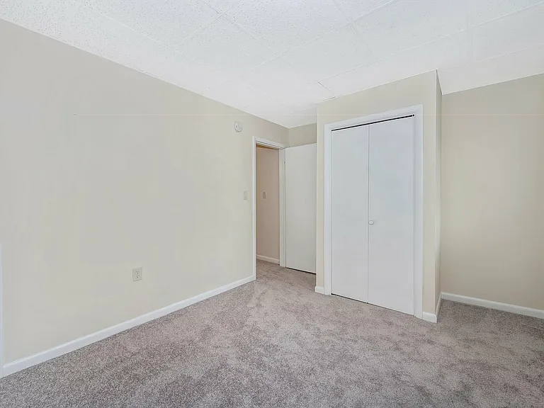 Experience tranquility in this bright, roomy bedroom, featuring plush carpeting and ample storage.