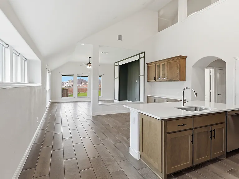 Open concept living space featuring wood-finish flooring, vaulted ceilings, and an abundance of natural light