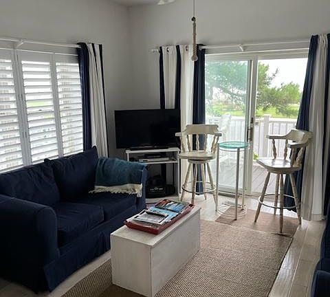 Living room with sliding doors to deck, ocean view and new hardwood floors