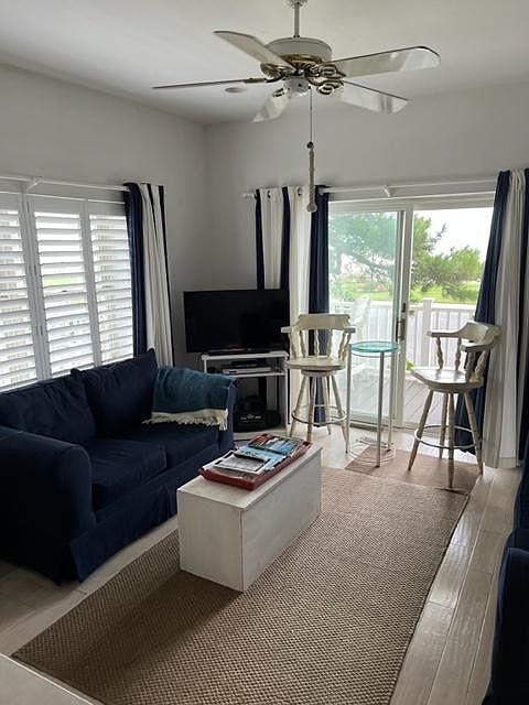Living room with sliding doors to deck, ocean view and new hardwood floors