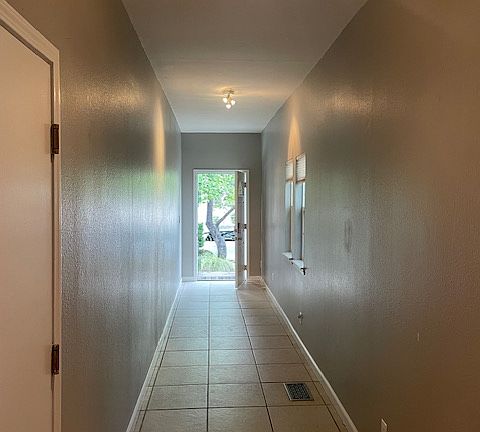 Looking back down the long hallway to the front door and street; this hallway makes a great gallery space for your art or posters!