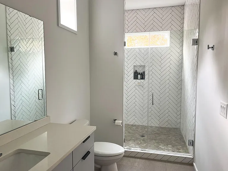 Full bathroom with stand up tiled shower and with single sink