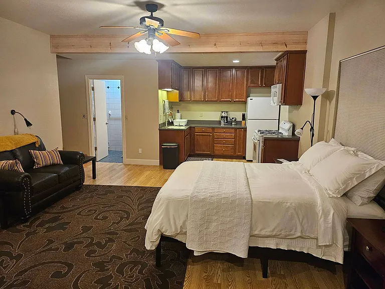 Ceiling fan and view into bathroom; Queen bed; large window