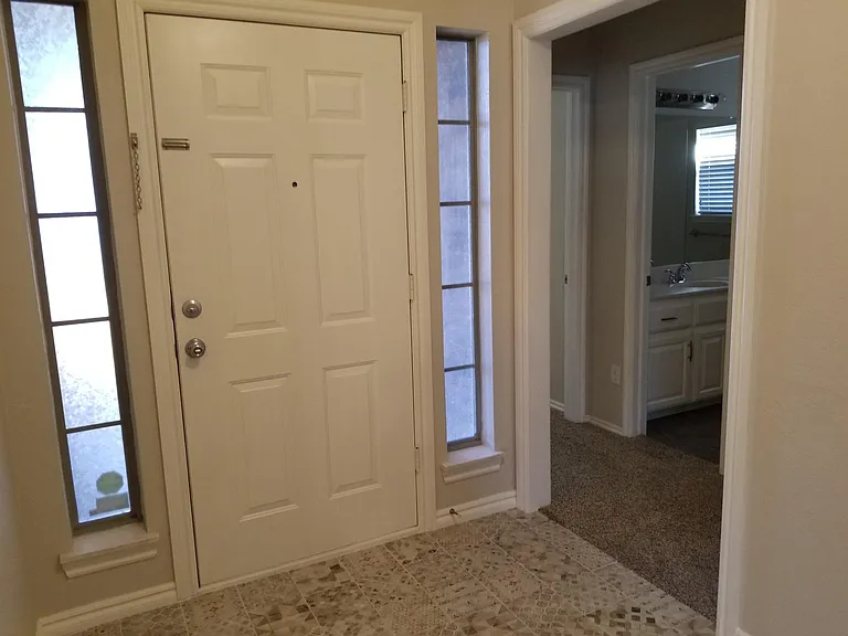 Entry door and hallway to two bedrooms and bathroom.