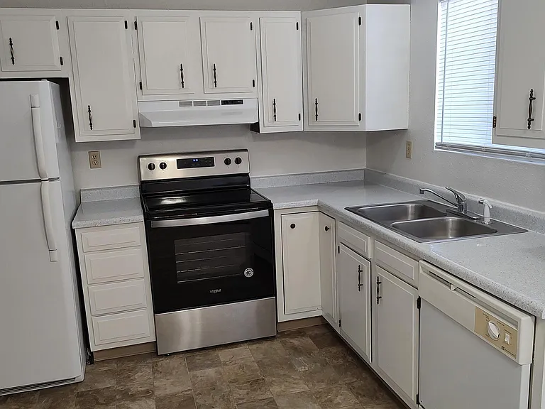 The spacious kitchen has nice appliances including a dishwasher, and a sliding glass door to the patio and rear yard.