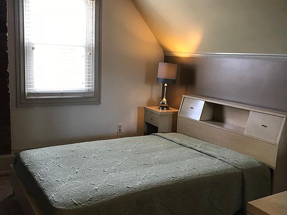 Main bedroom with fill size bed, dresser with large mirror and two nightstands