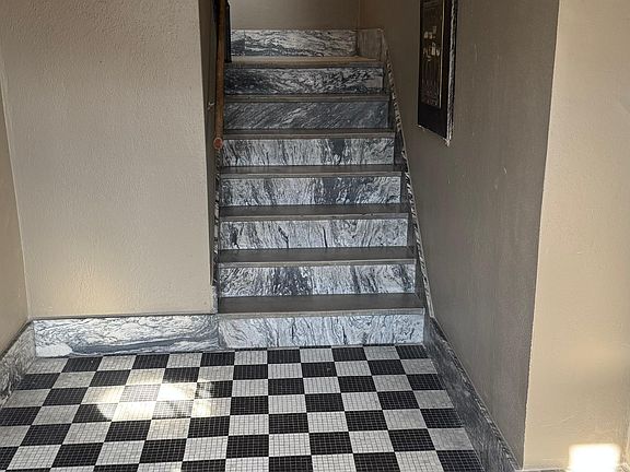 Secure building entry with updated flooring and clean common areas leading to the residential units