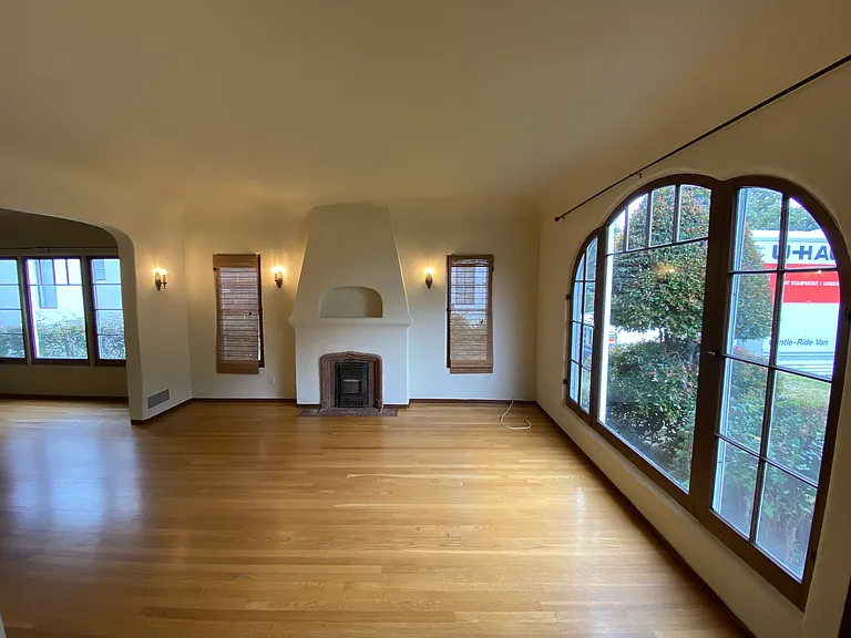 LARGE LIVING ROOM WITH FAUX 1920s BATCHELDER TILE FIREPLACE AND LARGE PICTURE AND FRENCH WINDOWS