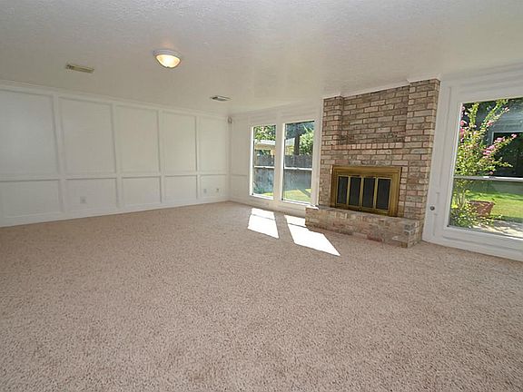 Spacious family room featuring a wood burning fireplace with gas starter, built-in bookshelves and French door to the patio area.