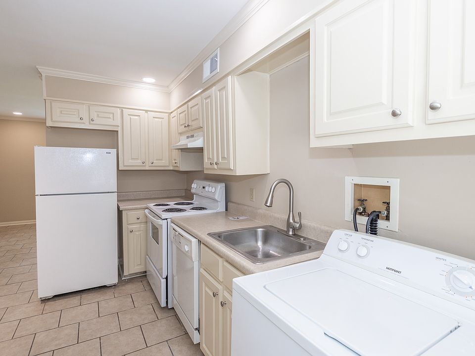 Kitchen area with all appliances: stove, refrigerator, washer & dryer with lots of cabinet space.