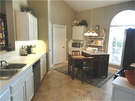 Large eat in kitchen, updated appliances, tile floors, high ceilings, door to left goes to utility room