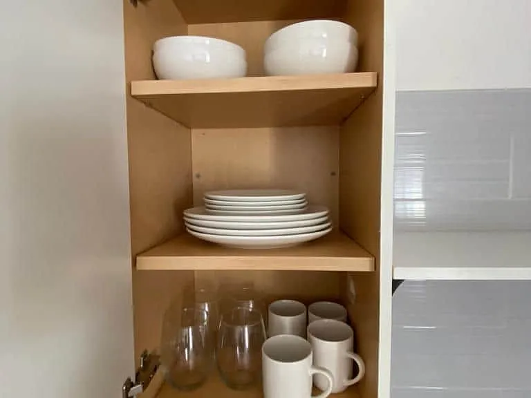 Fully equipped with dinnerware including deep bowls, flat plates, glassware, and cups.