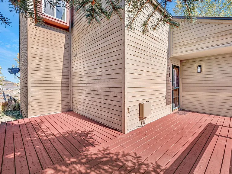 #207 is an end unit, with a wrap around front deck, small back storage shed, and parking area out front