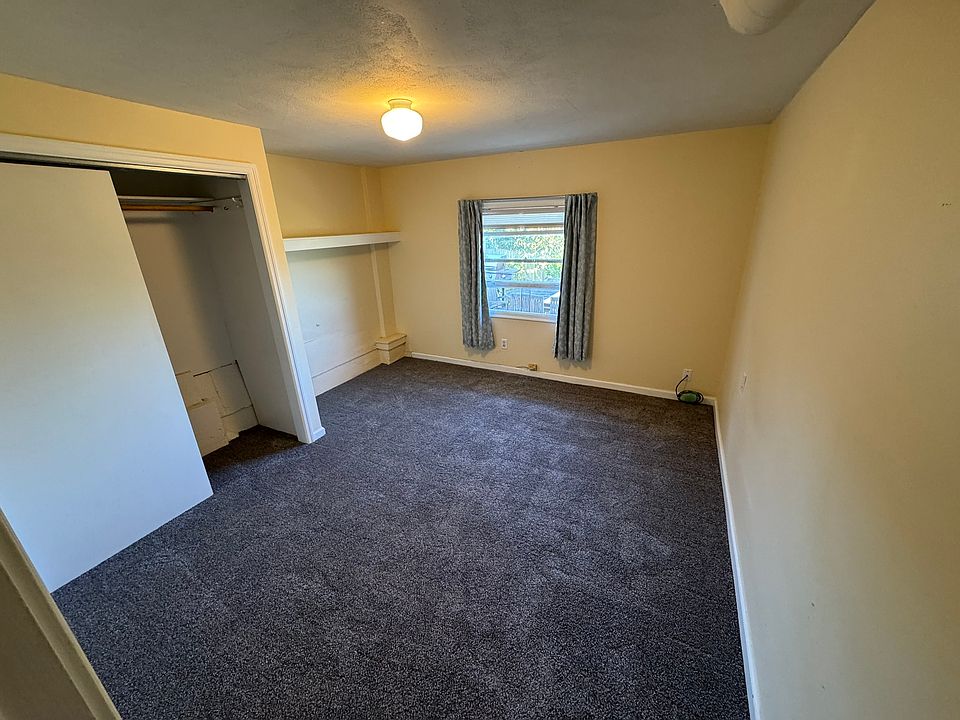 Bedroom with large closet and west-facing window overlooking garden.