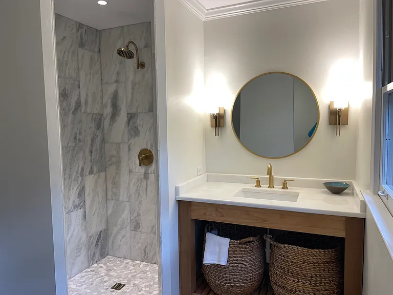 Toilet is tucked behind a wall visible in mirror