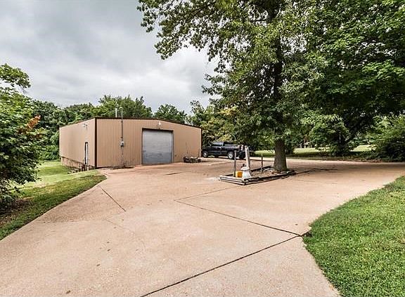 40X60 metal outbuilding features concrete floors, an oversized door with an opener, 200-amp electric