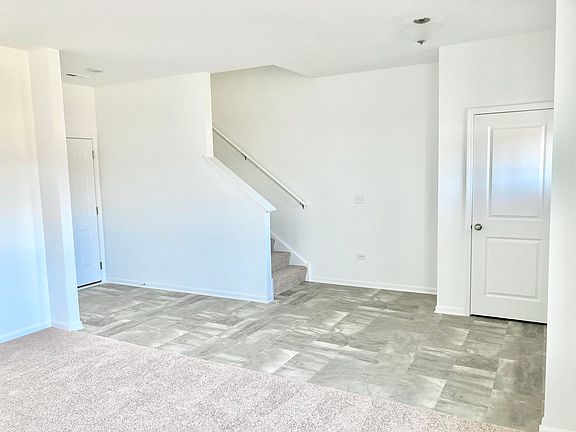 Coat closet by entrance door, and stairs off foyer, with door to garage in back