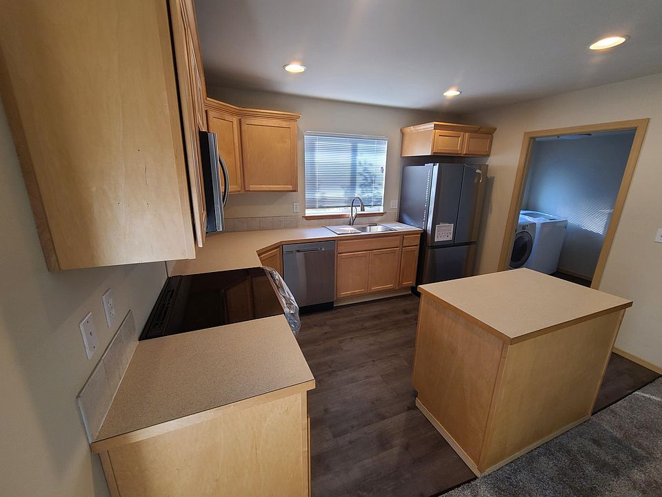 Kitchen with new range, stainless sink and refrigerator.
