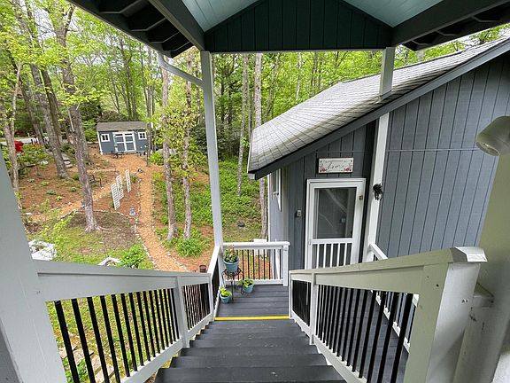 Stairs down to Airbnb then on down to small Executive Apartment. She shed and property paths in the background.