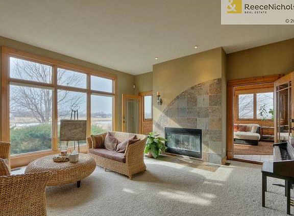 Living room with wall of windows and fire place just steps from