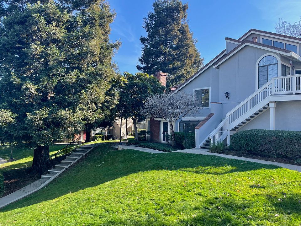 Front of house, surrounded by lush lawns on two sides.