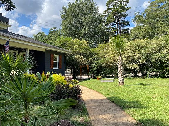 Walkway to front door with palms on each side and mature 13ft Palmetto in front yard.