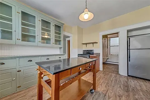 Kitchen features restored original built in glass front cabinets and stainless appliances. The stove top is flat glass/ceramic for ease of cleaning.