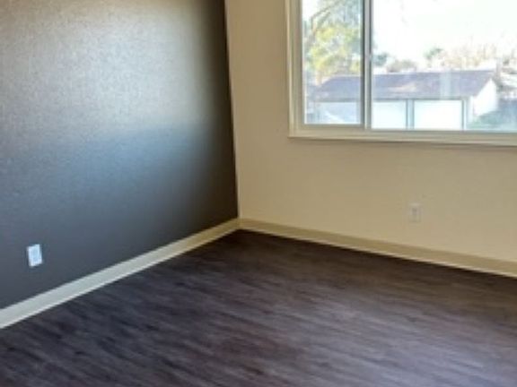 Living room with newer oversized dual-paned windows and screens, new paint, new blinds, and new flooring