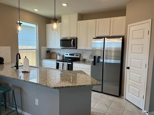 Open kitchen with lots of light, granite counter tops, new appliances.