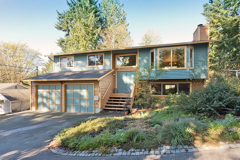 To the left of the garage in this photo is another extra long parking space which can accommodate two more cars. The tri-color paint job compliments the incredible garden surrounding the home.
