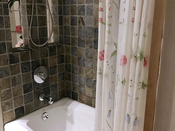 Remodelled, custom slate-tiled bathroom with new tub and fixures.