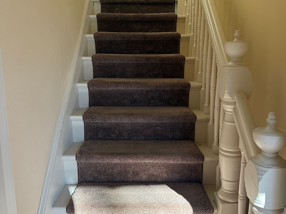 Carpeted stairway inside entry to two bedroom apartment